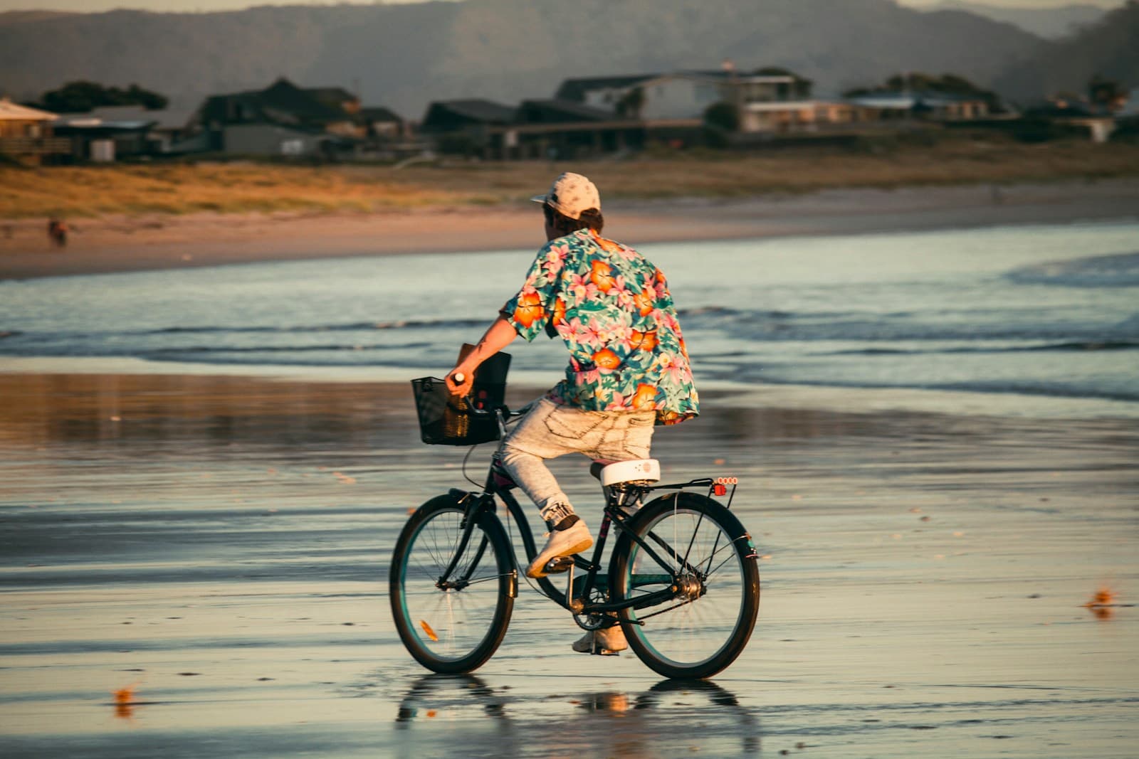 Una persona pasea en bicicleta junto al mar al atardecer